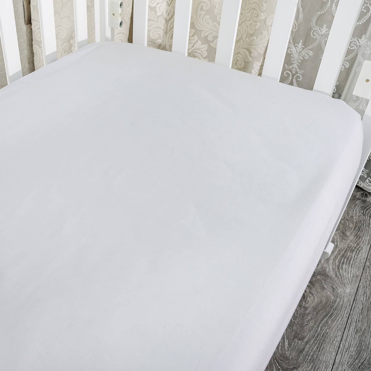 part of baby cot, close up. Mattress and sheets in white crib.